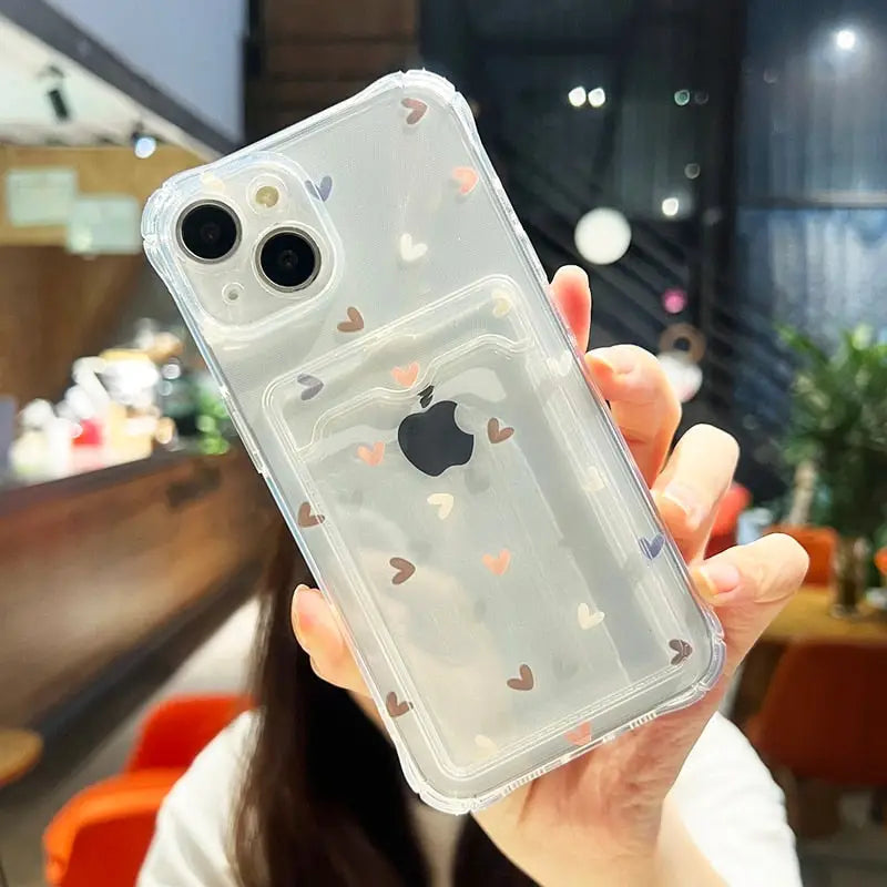 a woman holding up a clear case with hearts on it