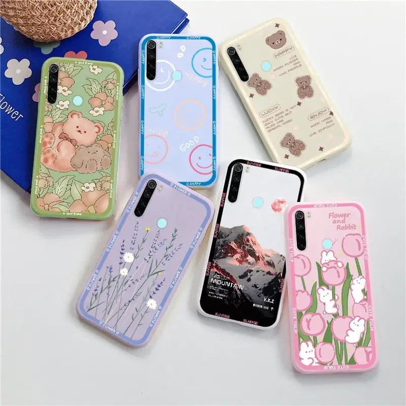 several different cases are arranged on a table with a teddy bear