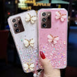 a woman holding two iphone cases with butterflies on them