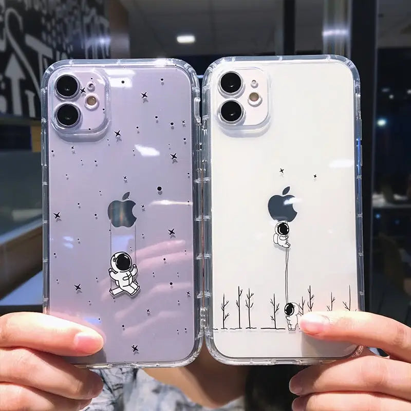 a person holding up two iphone cases