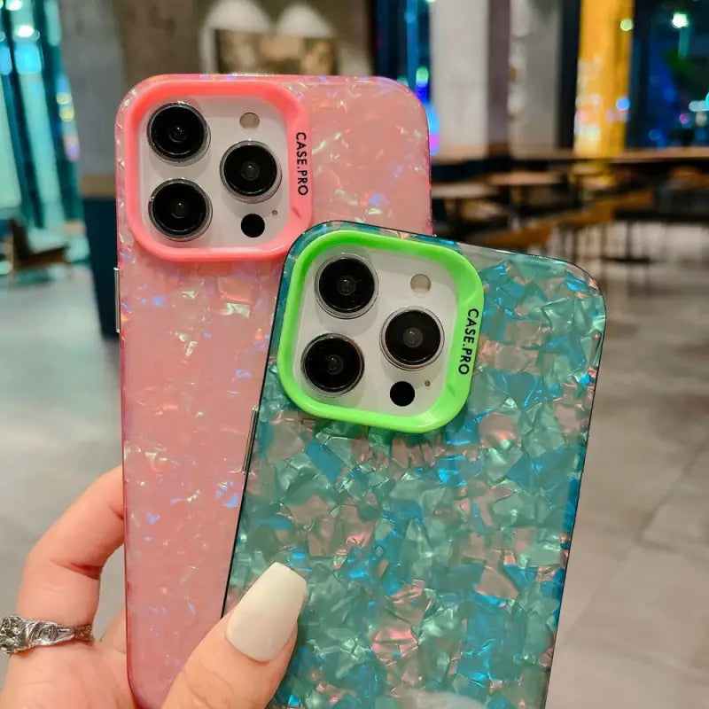 a hand holding a phone case with a pink and blue marble pattern