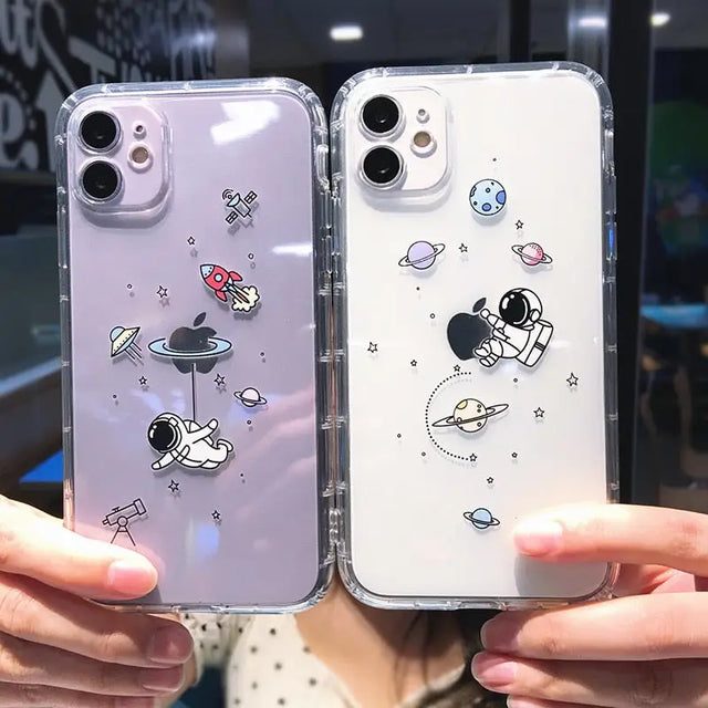 a woman holding two iphone cases with space and planets on them