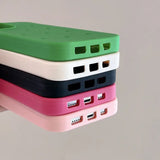 a small green and pink case with a white and black cover