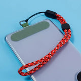 there is a cell phone with a red rope attached to it