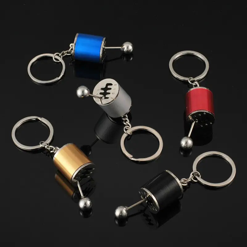 several different key chains with a metal bell on a black background