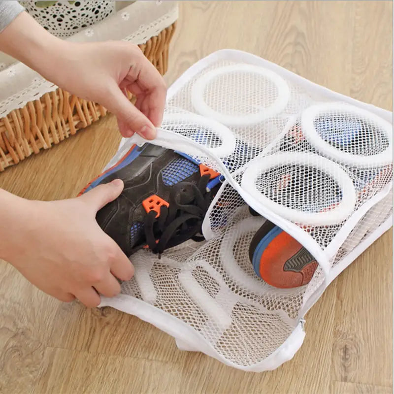 a child putting a pair of shoes into a mesh bag