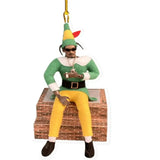 a christmas orname with a man sitting on a brick