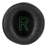 Circular black cushion or ear pad with a glowing green ’R’ in the center.