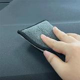 a hand is cleaning the dashboard of a car