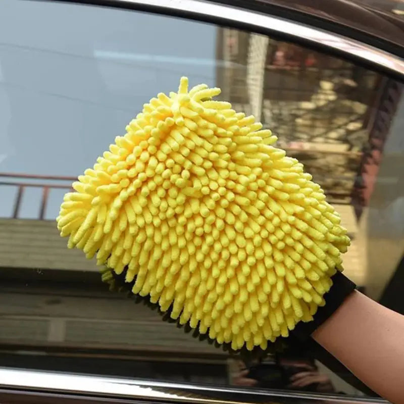 a person cleaning a car with a sponge