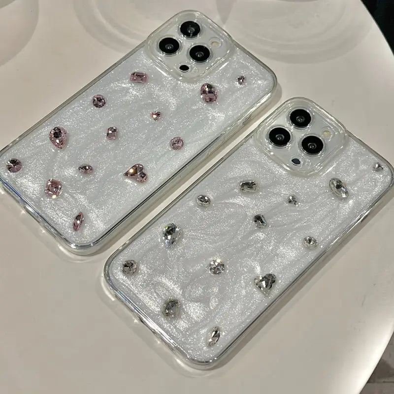 two clear cases with crystals on them