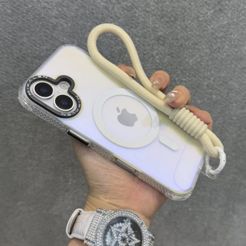 A clear iPhone case with a beige wrist strap, a black camera accent, and an Apple MagSafe charger.