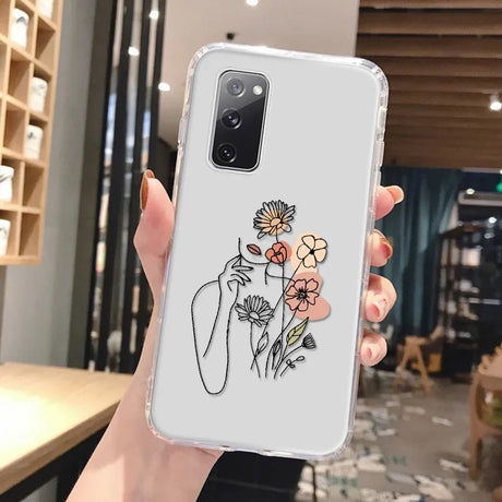 Clear phone case with abstract art design of a woman holding flowers in peach orange and muted pink for samsung galaxy back side