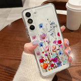 Clear phone case for samsung galaxy with embedded dried flowers in vibrant pink blue red and orange hues backside view