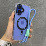 Clear phone case with a purple back, black camera lens protector, a black MagSafe ring, and a light blue braided wrist strap with mint green silicone rings.