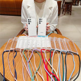 Clear phone cases with colorful lanyards.