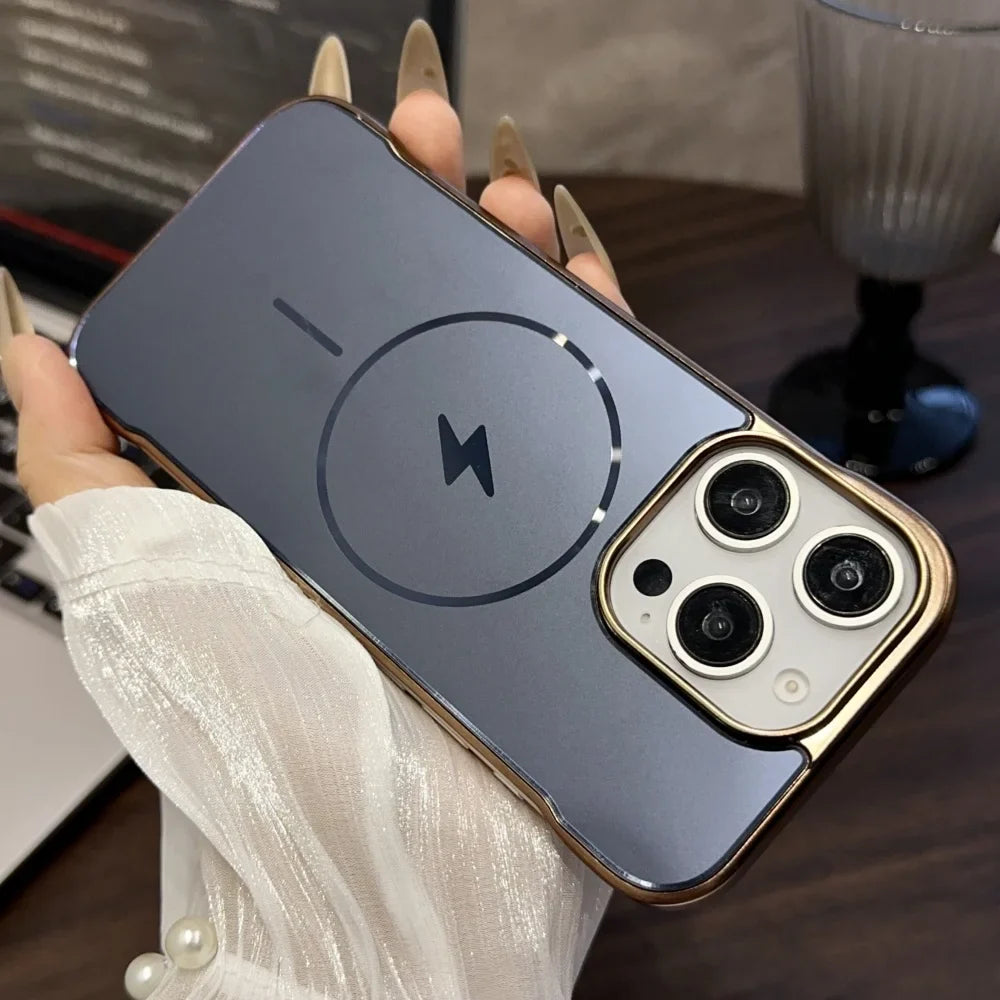 A clear smartphone case with a gold metallic frame, prominent camera cutouts, and a visible MagSafe charging ring and lightning bolt icon.