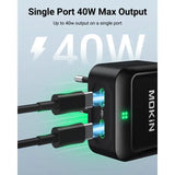 A close up of a black power adapter with a green light