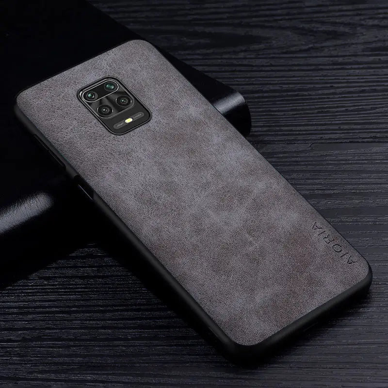 the back of a gray leather case on a black table
