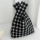 a close up of a black and white bag with a bow