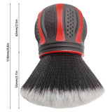 a close up of a brush with a red handle on a white background