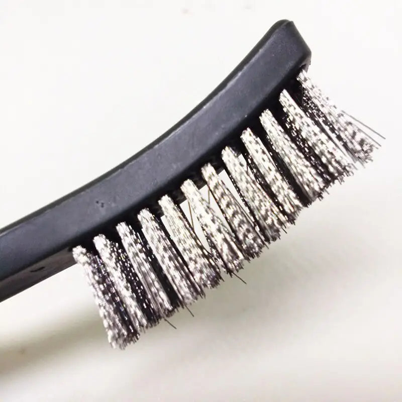 a brush with a metal handle on a white surface