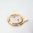 a close up of a cat shaped mirror on a white surface