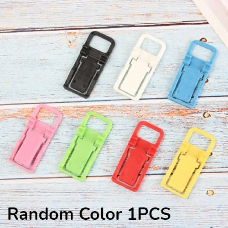 a bunch of colorful plastic clips on a white wooden background