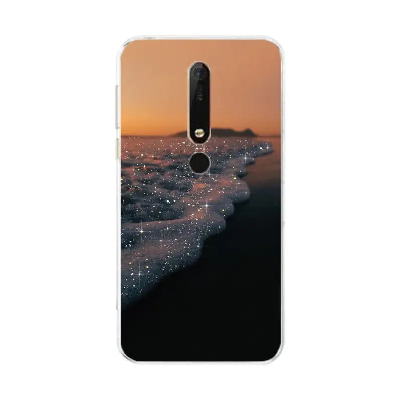 a close up of a cell phone with a sunset on the beach