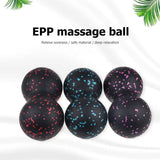 a set of five black and pink massage balls with a palm leaf in the background