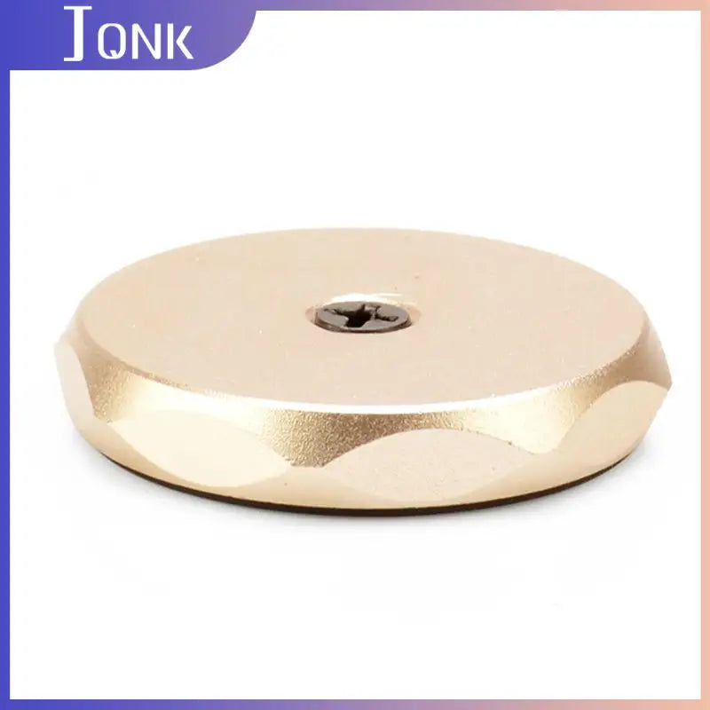 a gold plated disc with a hole