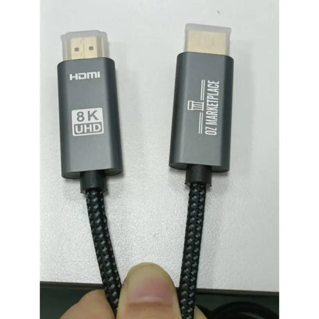 A close up of a person holding a black and white cable