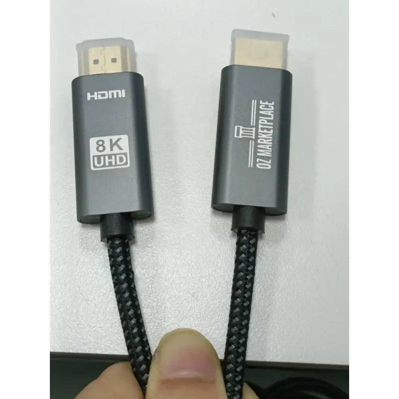 A close up of a person holding a black and white cable