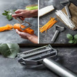 a close up of a person peeling carrots with a mandolin