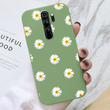a close up of a person holding a green phone case with daisies on it