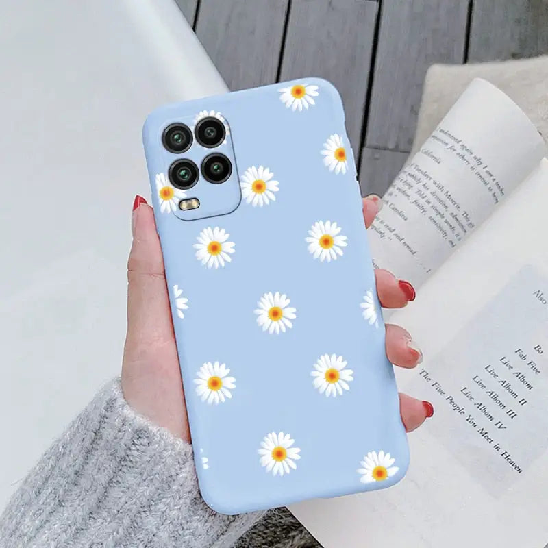 someone holding a phone case with daisies on it