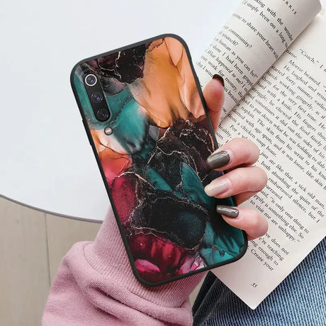 a woman holding a book and a phone case