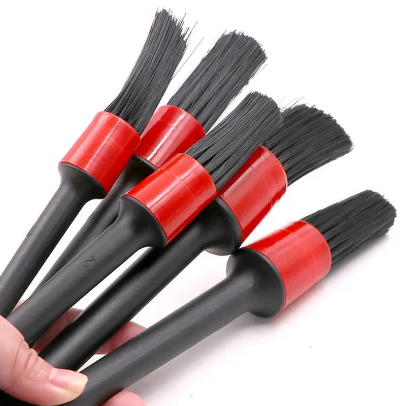 a close up of a person holding a bunch of black and red brushes