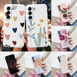 a woman holding a phone case with heart and flower design