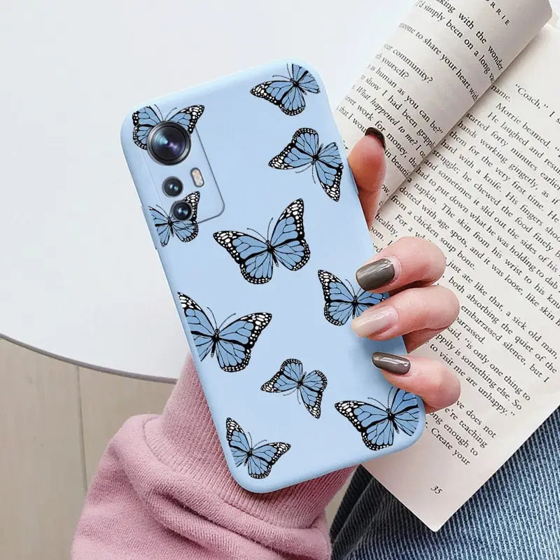 a woman holding a book and a phone case