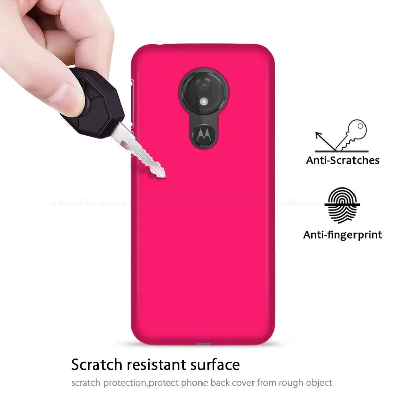 a hand holding a pink phone case with a key