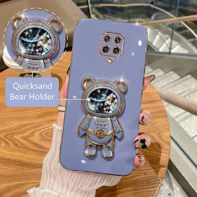 someone holding a phone with a bear design on it