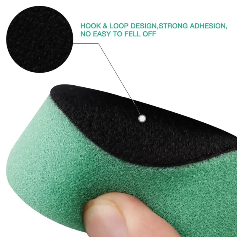 a close up of a person holding a green sponge with a black dot