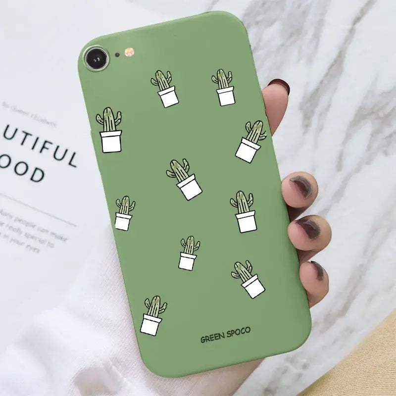 a close up of a person holding a green phone case with cactuses
