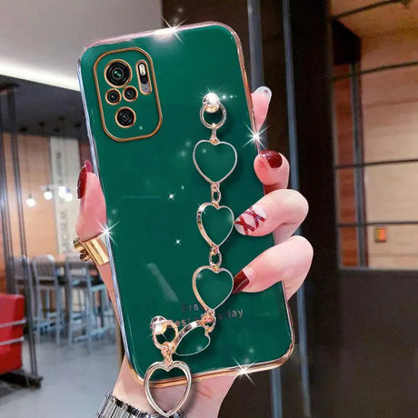 a close up of a person holding a green phone case with a heart and keychain