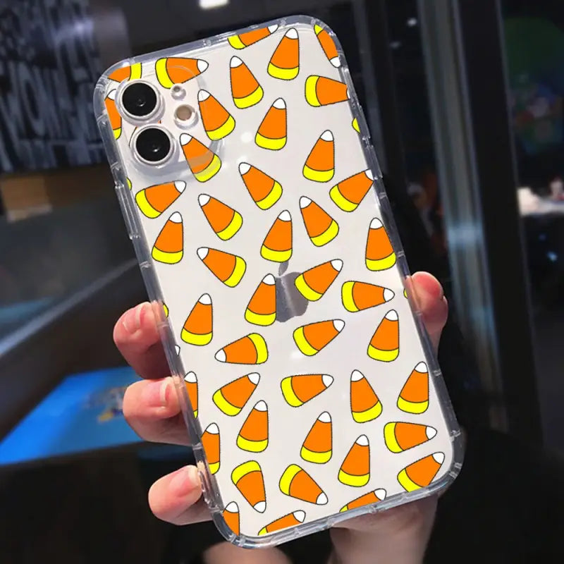 a close up of a person holding a phone case with candy corn