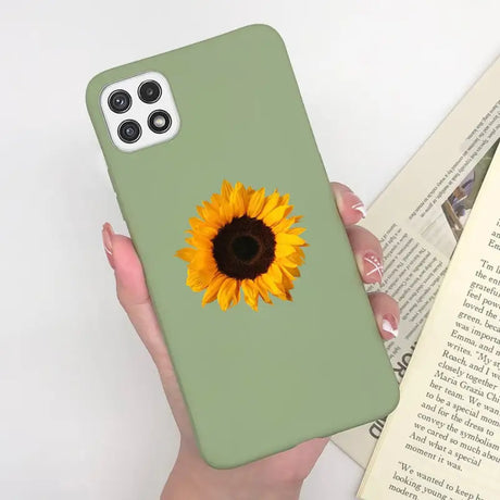 a woman holding a phone case with a sunflower on it