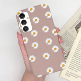 someone holding a phone case with a daisy pattern on it