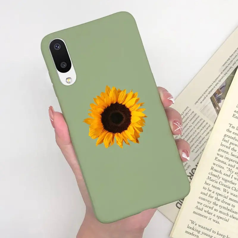 a woman holding a book and a sunflower