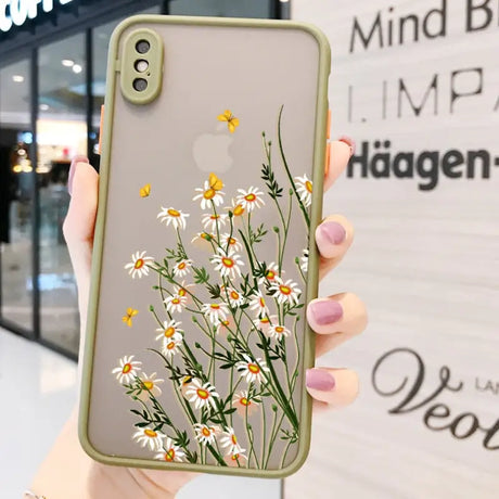 a woman holding up a phone case with flowers on it